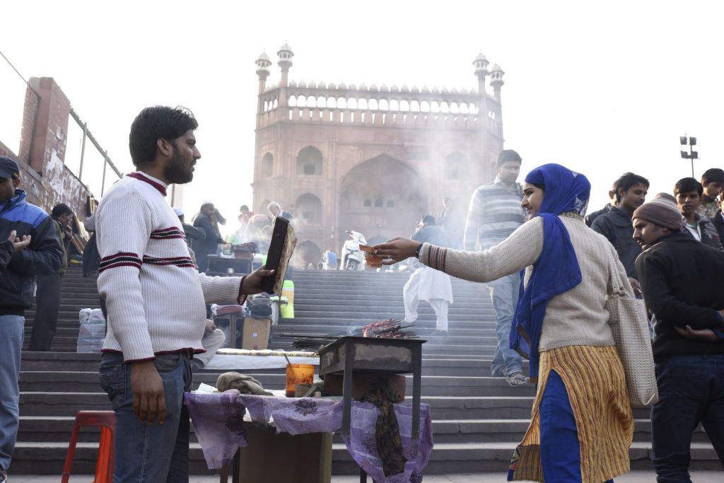 A man fans his kebabs as a woman comes by to buy some in front of Jama Masjid in Old Delhi, India's largest mosque. (Richard McGuire photo)