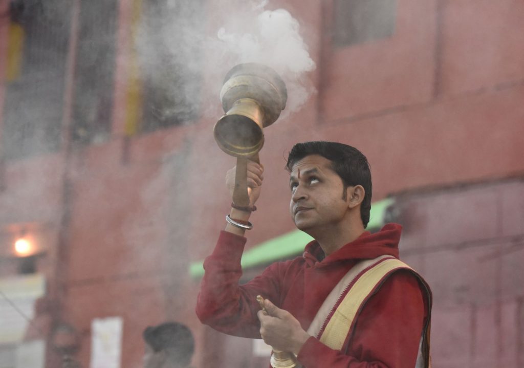 A priest performs a Hindu ritual to honour the Mother Ganges river as the sun rises at Varanasi. (Richard McGuire photo)