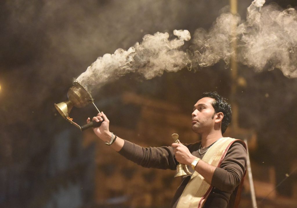 A priest waves burning incense around him during the evening ceremony on the Ganges at Varanasi. (Richard McGuire photo)