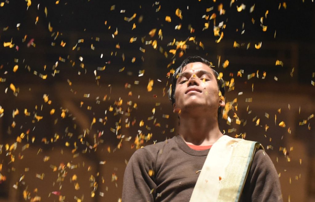 A priest is showered in flower petals that he has thrown into the air during the evening ceremony by the Ganges in Varanasi. (Richard McGuire photo)