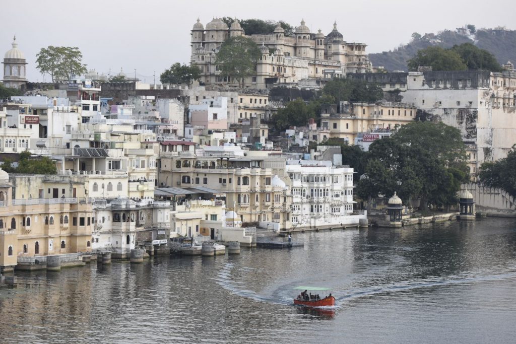 A tour boat cuts through the waters of Pichola Lake below the City Palace in Udaipur. (Richard McGuire photo)