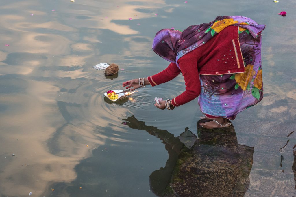 A Hindu woman sets afloat an offering with a burning flame in the Shipra River at Ujjain, one of India's holy cities in Madhya Pradesh. (© Richard McGuire photo)