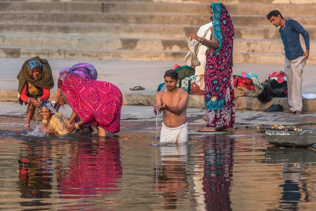 These people came to the Shipra River at the holy city of Ujjain to bathe early in the morning. The young woman in yellow on the left needed a bit of coaxing to go into the water. (© Richard McGuire photo)