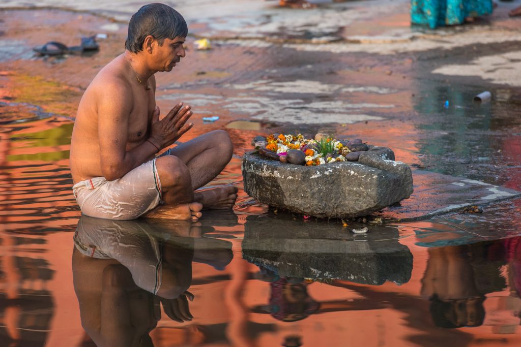 A Hindu man prays next to the Shipra River early in the morning in the holy city of Ujjain, Madhya Pradesh, India. (© Richard McGuire photo)
