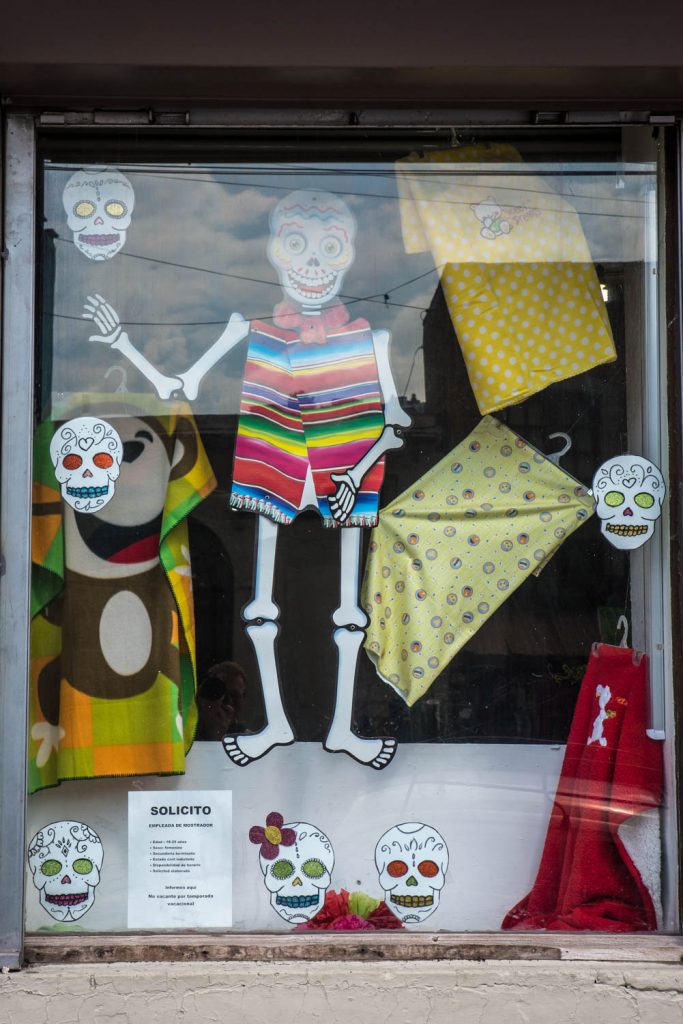 Images of skulls and skeletons decorate the window of a fabric and clothing store, Guanajuato, Mexico. (Richard McGuire photo)