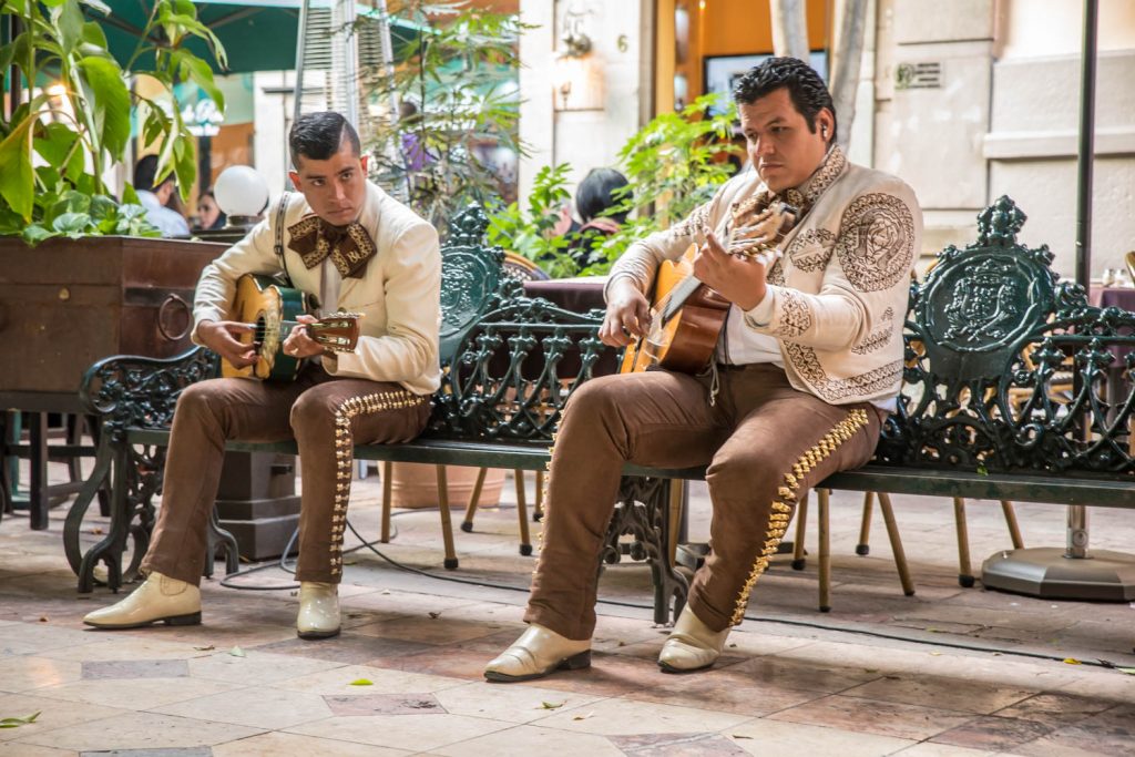 Two mariachis rehearse on a bench in Jardin de la Union as evening festivities approach. (Richard McGuire Photo)
